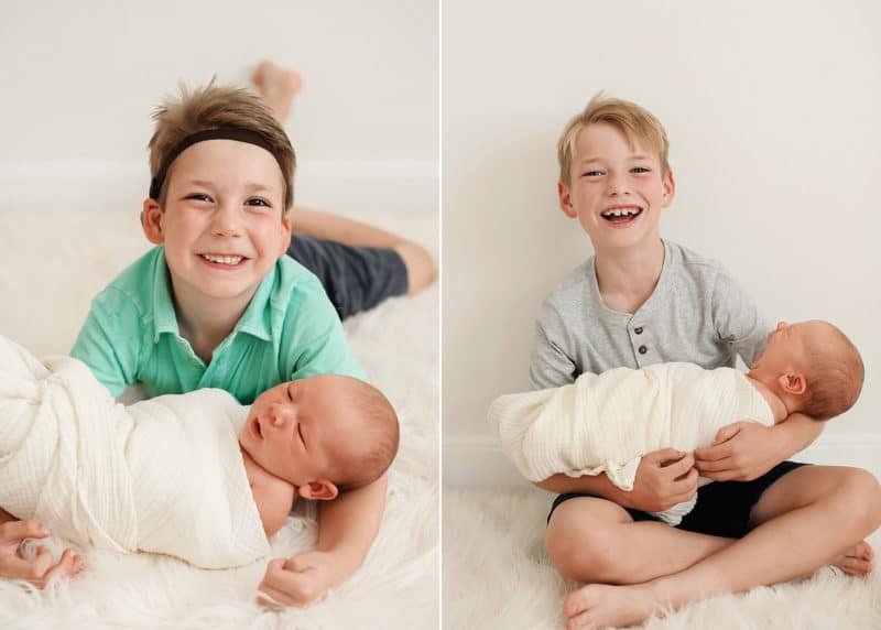 older brother holding newborn baby sibling and laughing and smiling during sacramento studio session