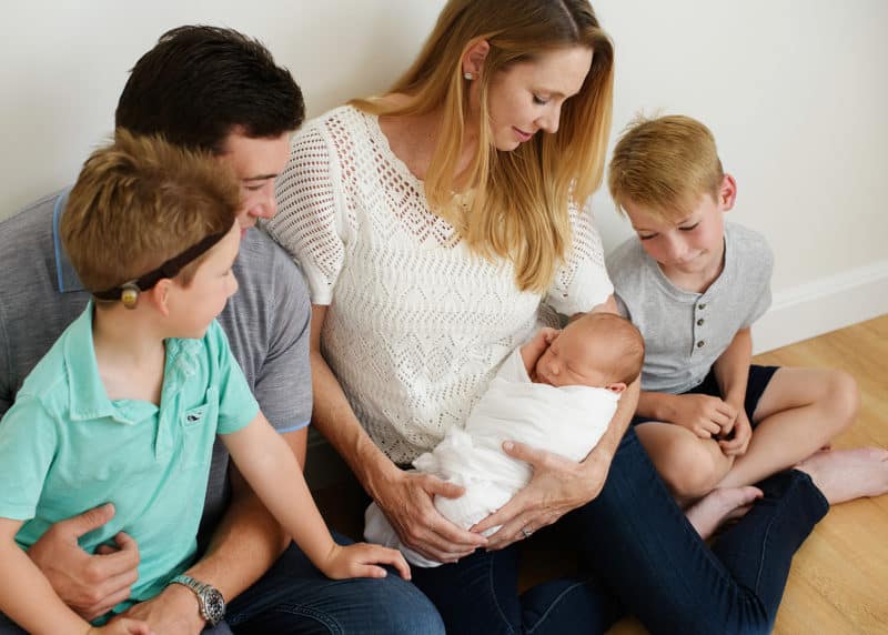 family of five looking at a newborn baby during studio session with sacramento photographer