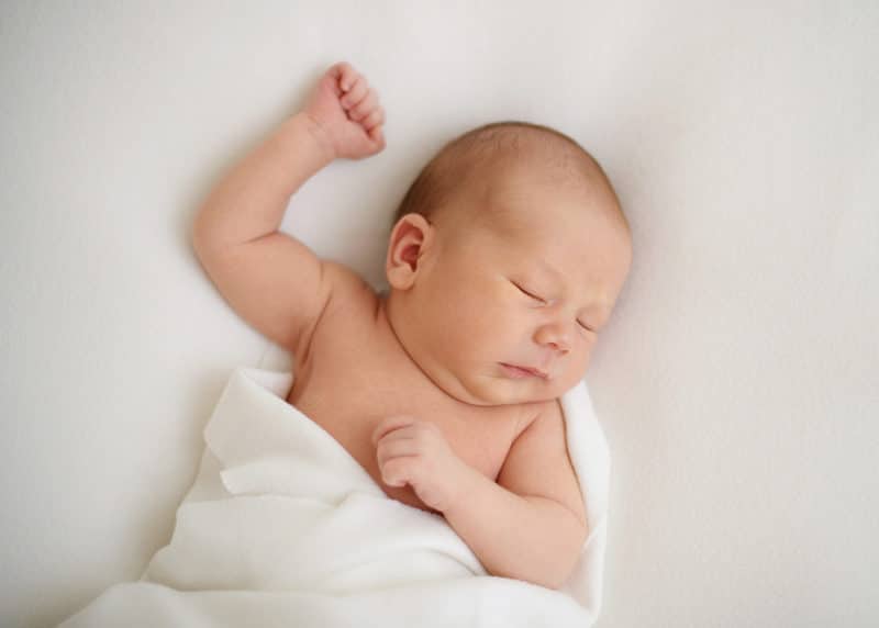 newborn baby sleeping with arm held up above their head during studio session with sacramento photographer jill carmel