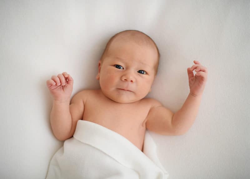 newborn baby looking at sacramento photographer jill carmel during newborn photo session in the studio