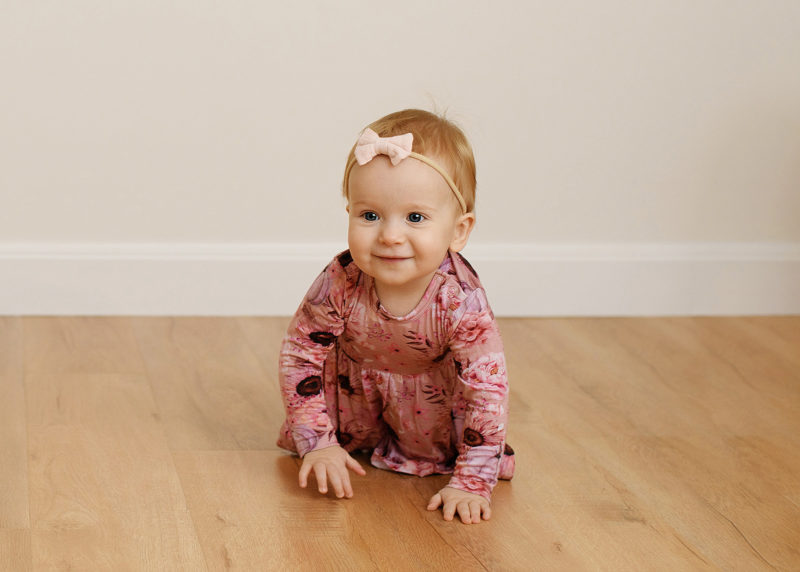 one year old girl wearing pink and crawling toward the camera during photo session with sacramento photographer jill carmel