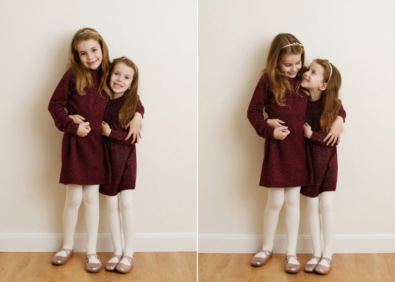 two older sisters wearing red dresses and white tights in a photo studio in sacramento california